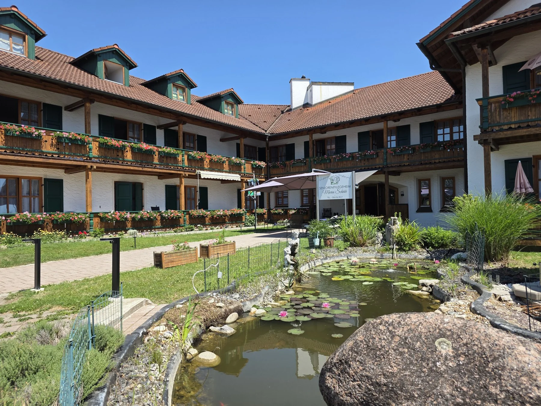 Geschützter Innenhof mit Gartenteich und Sitzplätzen im Seniorenpflegeheim Maria Schnee